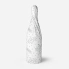 Silver floral patterned tissue paper wrapped around a bottle