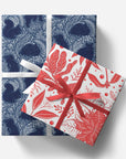 Two gift boxes with blue and white patterned box on top and red and white patterned box below, tied with ribbons.