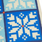 Close-up of a geometric patterned fabric with blue and beige colors.