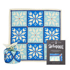 Gift wrap with blue and white pattern, wrapped present, and packaging on a white background