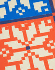 Close-up of a pixelated pattern with blue, red, and beige colors.