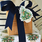 Gift basket with navy ribbon and Christmas tree-themed wrapping paper