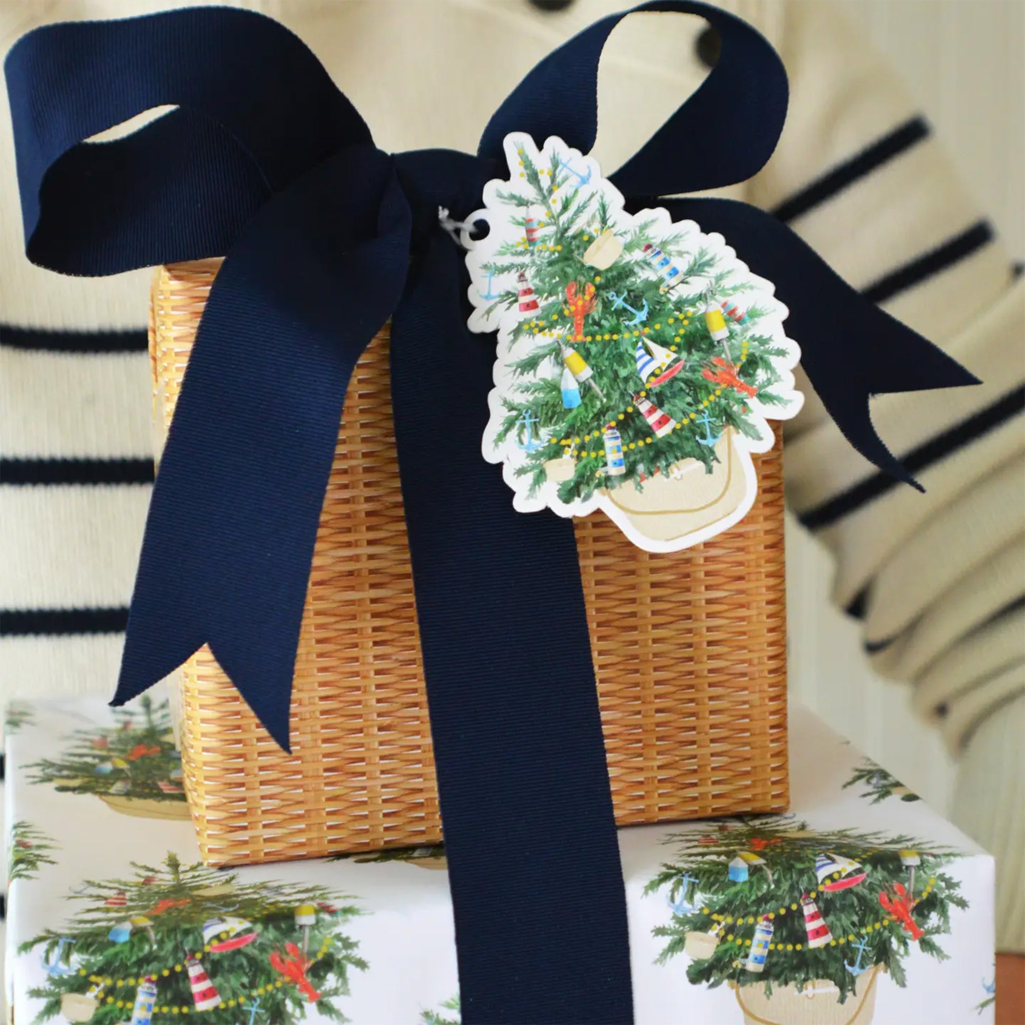 Gift basket with navy ribbon and Christmas tree-themed wrapping paper