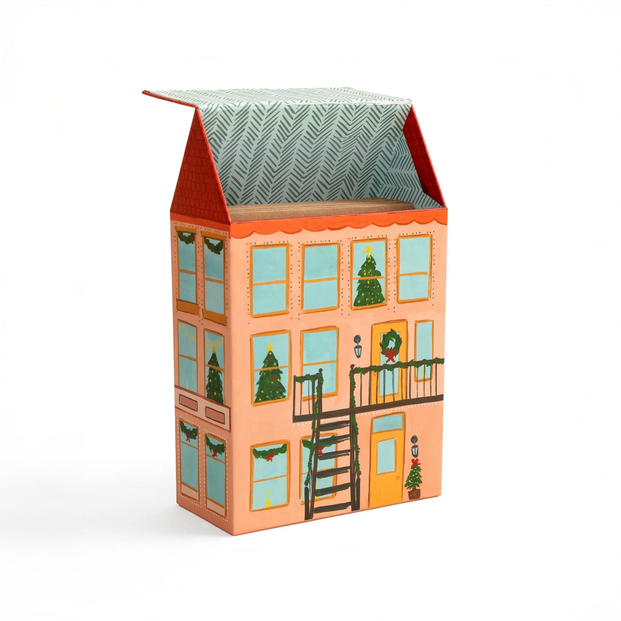 Decorative box designed like a house with Christmas trees and wreaths on a white background