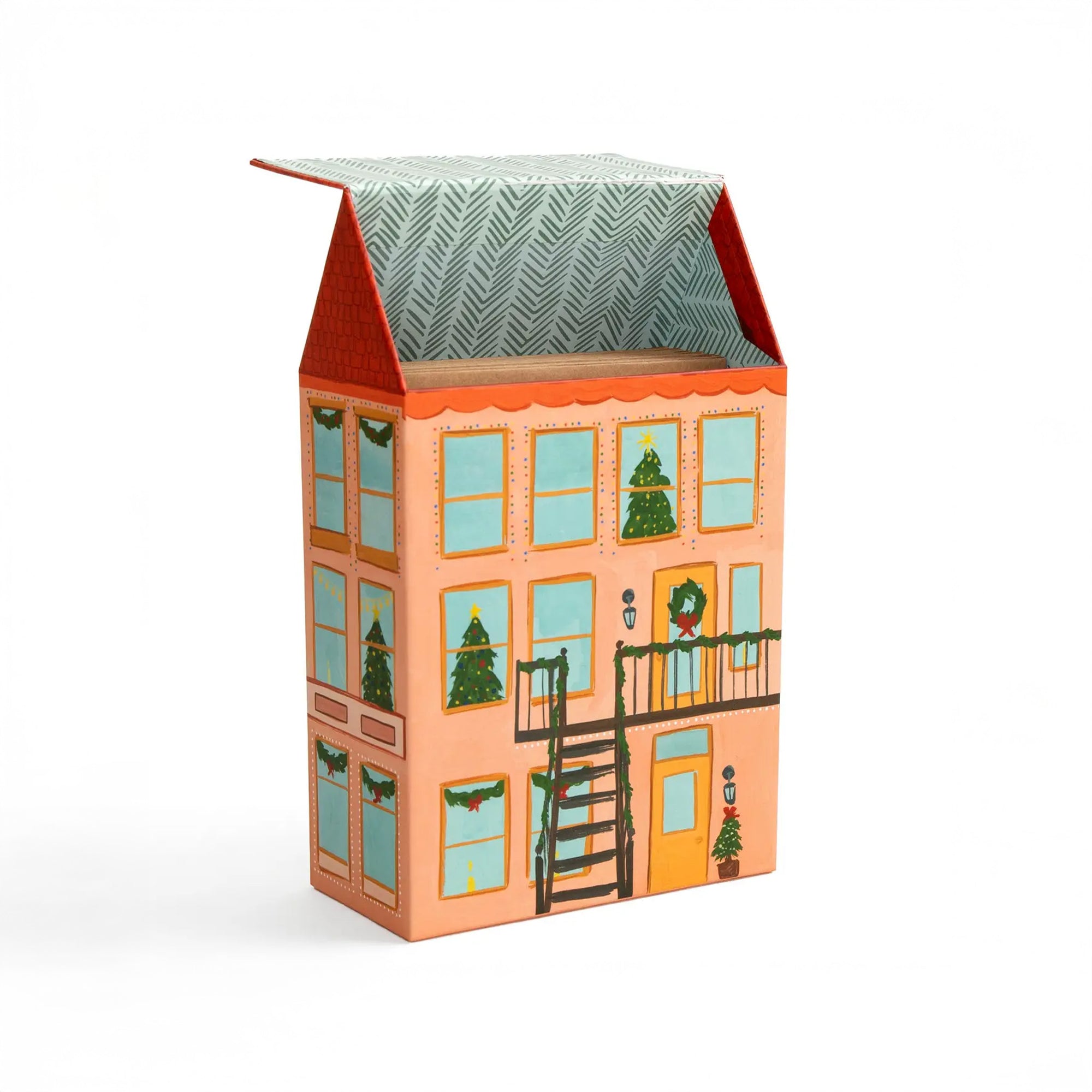 Decorative box designed like a house with Christmas trees and wreaths on a white background
