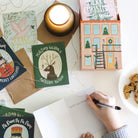 Handwriting on a card with Christmas cards and a candle in the background