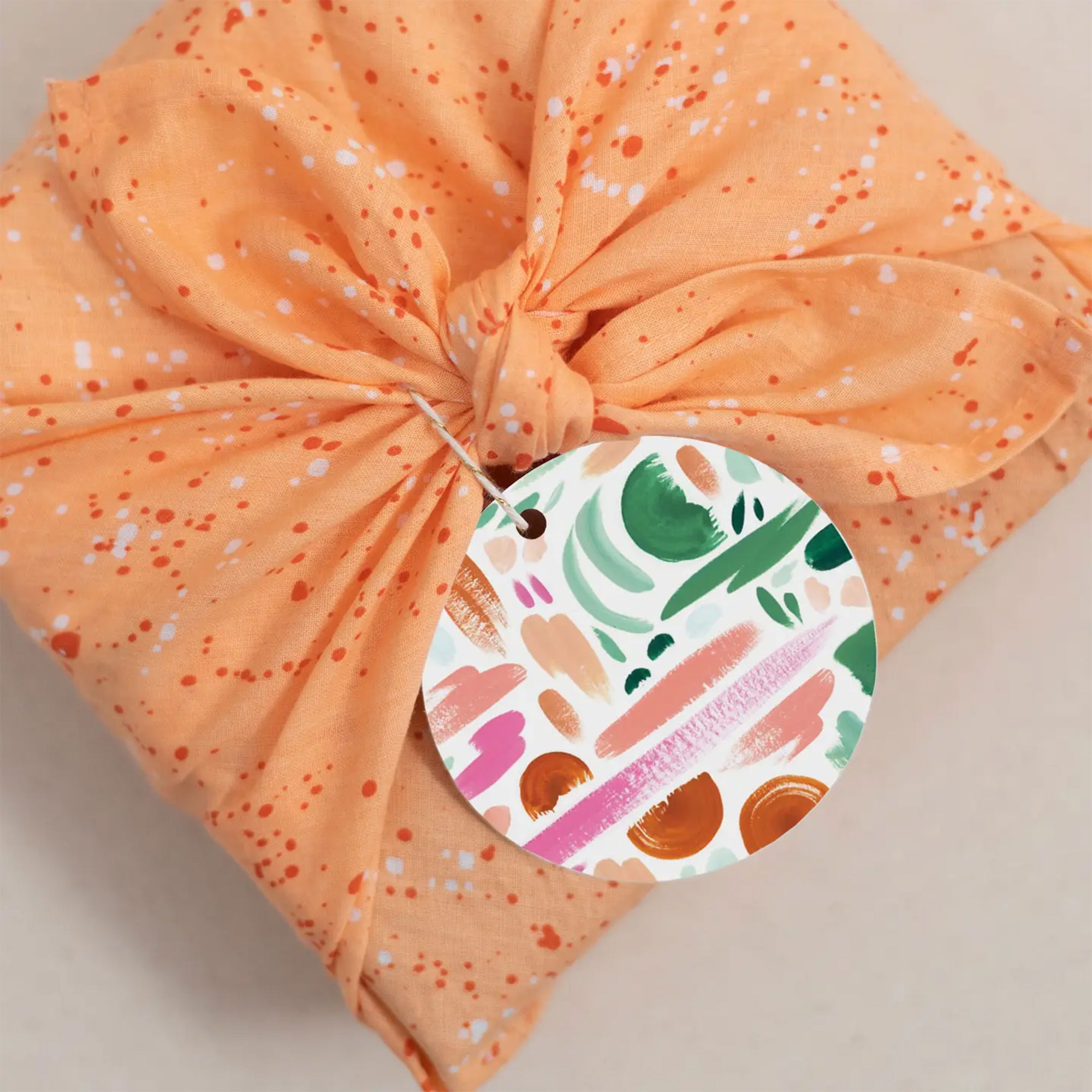 Colorful brushstroke gift tag on a wrapped gift