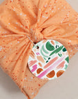 Colorful brushstroke gift tag on a wrapped gift