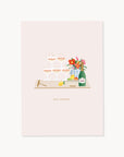 Greeting card with celebratory design featuring glasses, a bottle, and flowers on a light pink background.