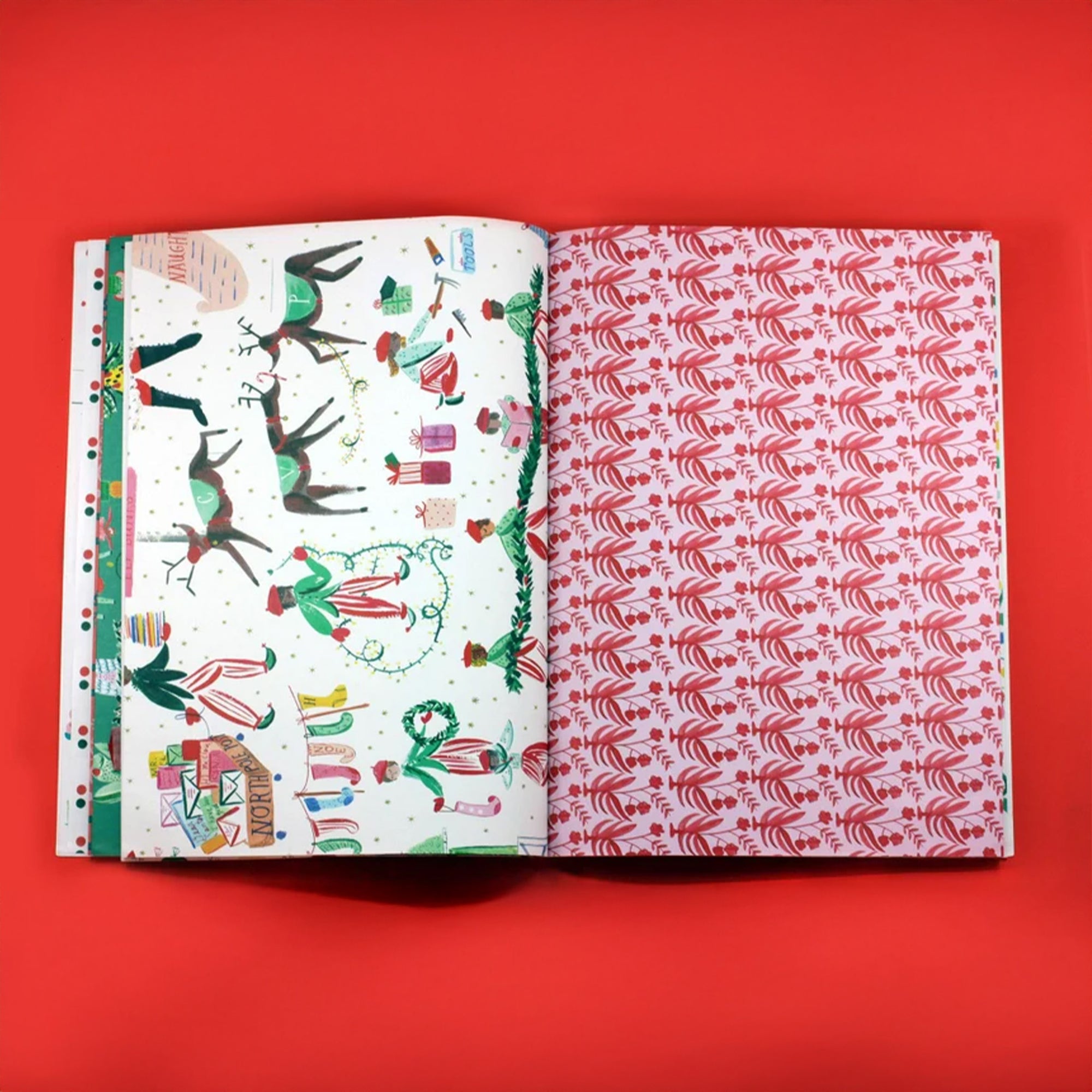 Open book displaying two different patterned two wrapping paper pages on a red background