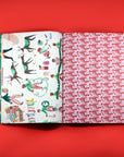 Open book displaying two different patterned two wrapping paper pages on a red background