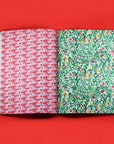 Two patterned books open to display red and green Two wrapping paper pages on a red background