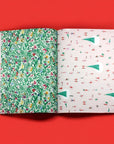 Two sheets of wrapping paper pages, one green with floral design and one white with tree design, on a red background.
