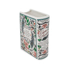 A decorative ceramic book-shaped vase featuring a floral and ornamental print inspired by Jane Austen's 'Pride and Prejudice'. The white ceramic book has a colorful pattern of pink flowers, green leaves, and black scrollwork, with the title and author name printed on the front and side.