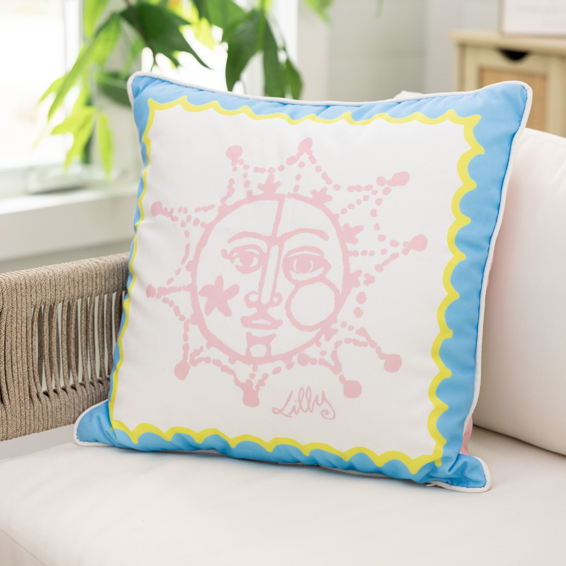 Decorative pillow with a pink face design on a white couch