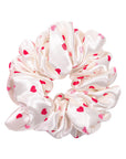 White scrunchie with red heart patterns on a white background