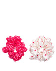 Two scrunchies, one pink with white stripes and one white with red heart patterns, on a white background.