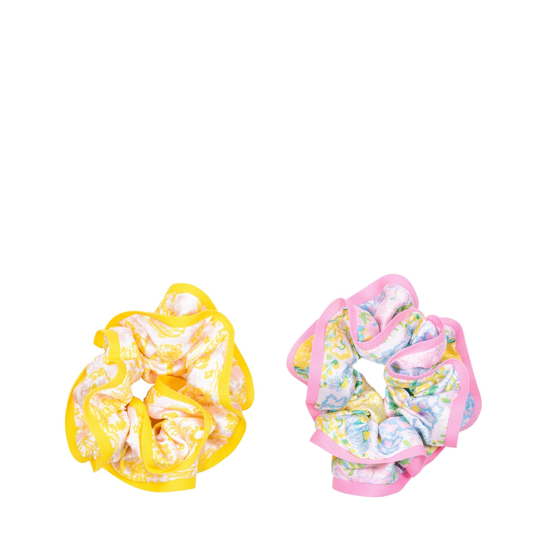 Two scrunchies, one yellow and one pink with floral pattern, on a white background.