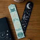 Two bookmarks with decorative designs on a wooden surface