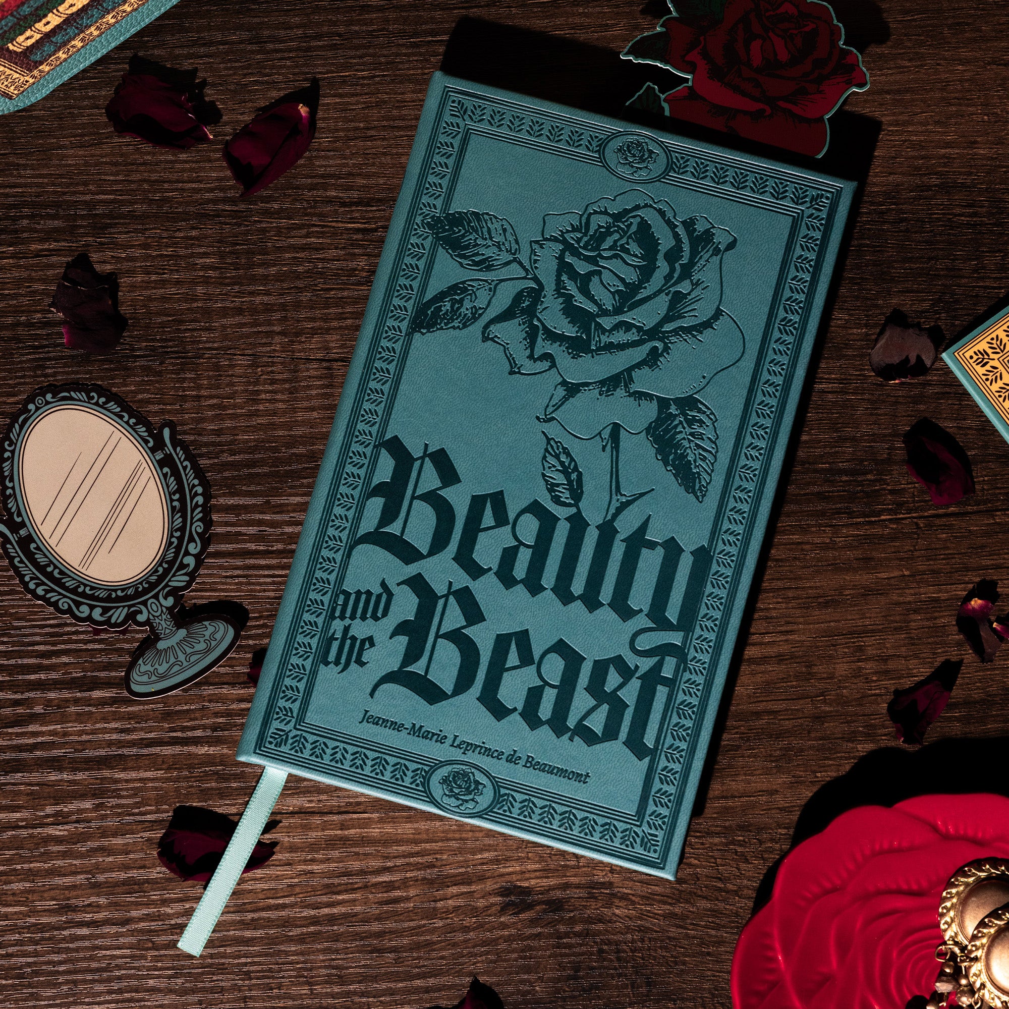 Teal notebook with rose design and 'Beauty and the Beast' text on a white background