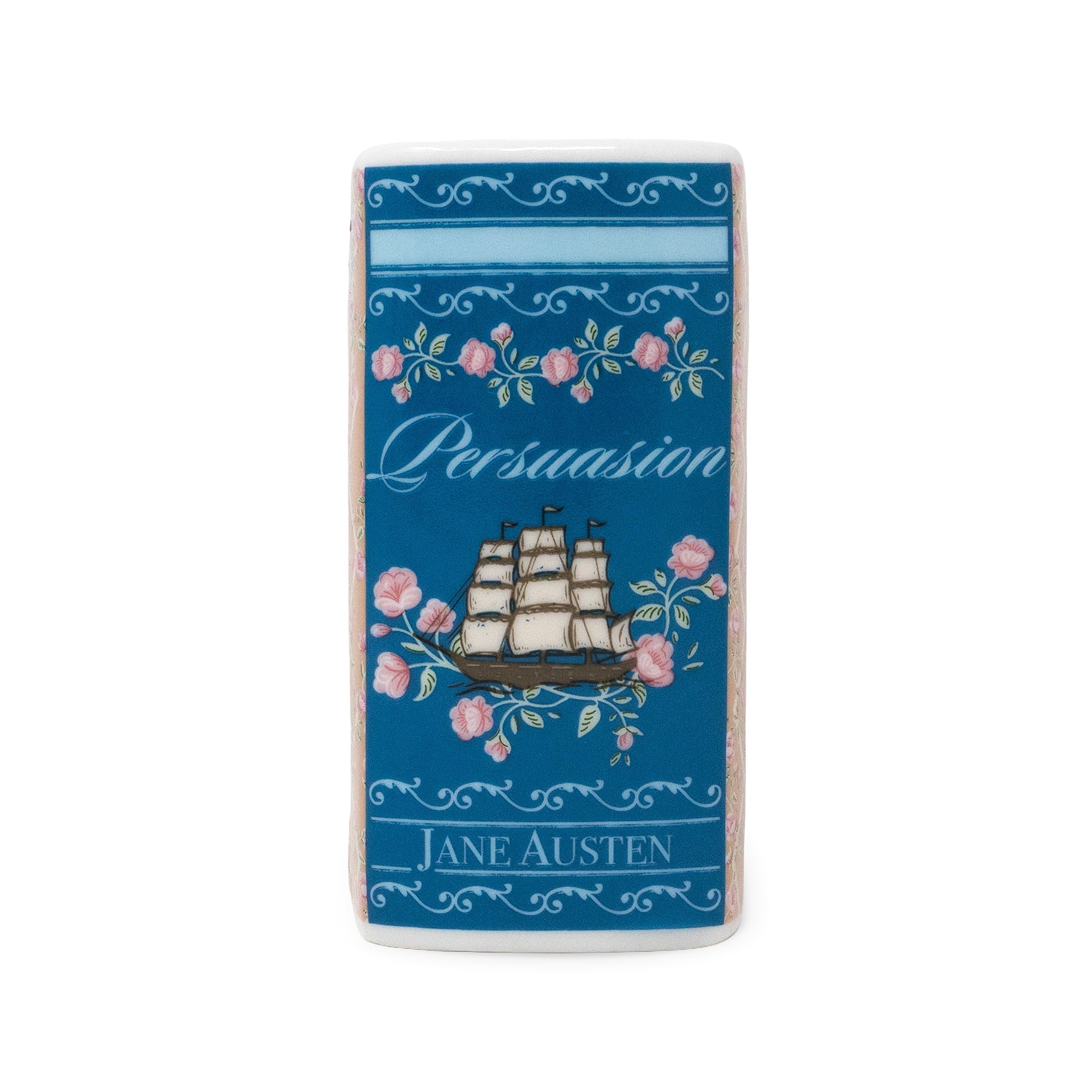 A rectangular ceramic candle with rounded corners featuring a blue and white design inspired by Jane Austen's 'Persuasion'. The design includes a pink rose and foliage pattern, a white sailing ship, and the text 'Persuasion' and 'JANE AUSTEN'.