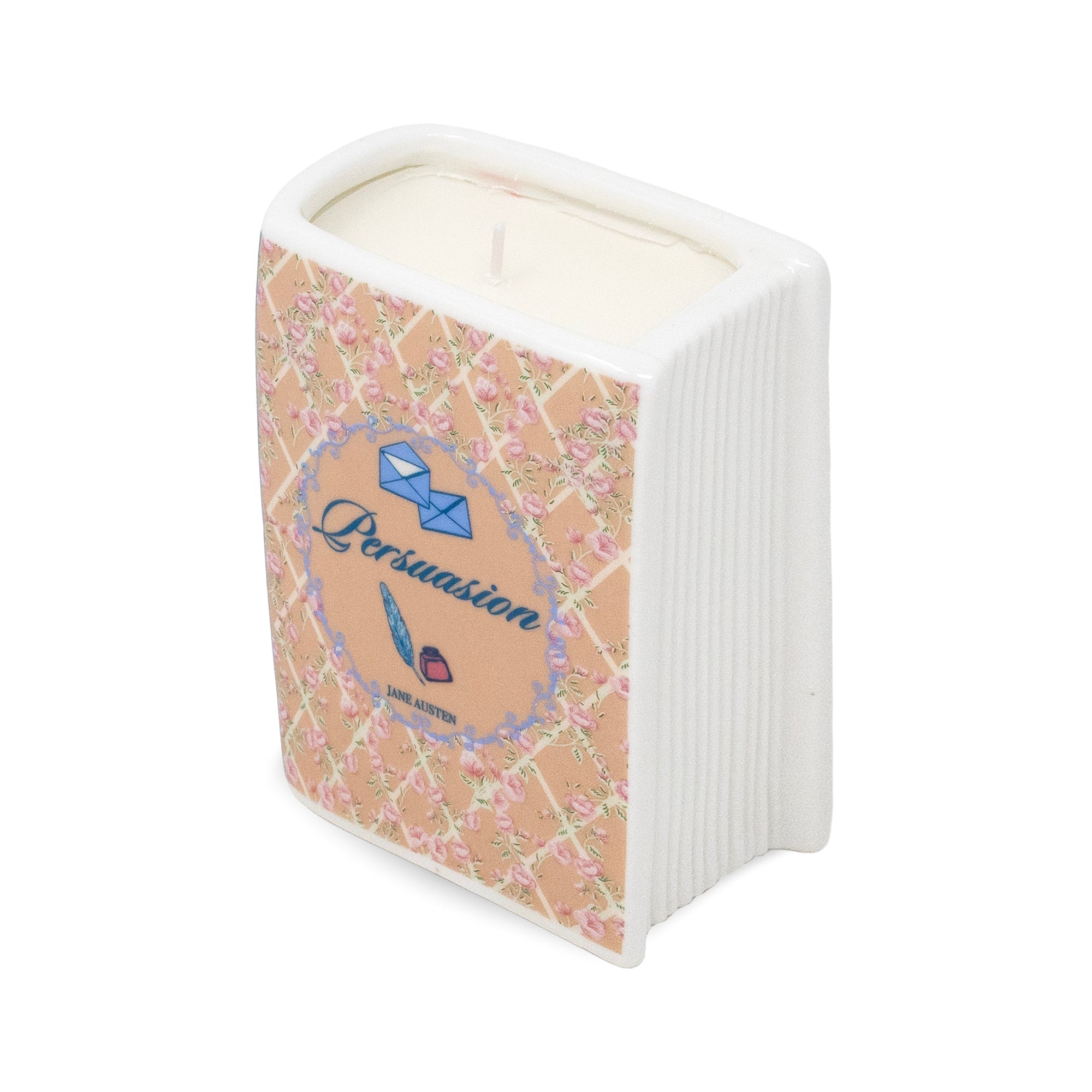 A novelty candle shaped like a book, featuring a white ribbed spine and cover with a pink floral lattice pattern, a central blue circular label reading 'Persuasion', and cream-colored wax visible at the top.
