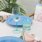Two turquoise glasses on a table with a blurred background
