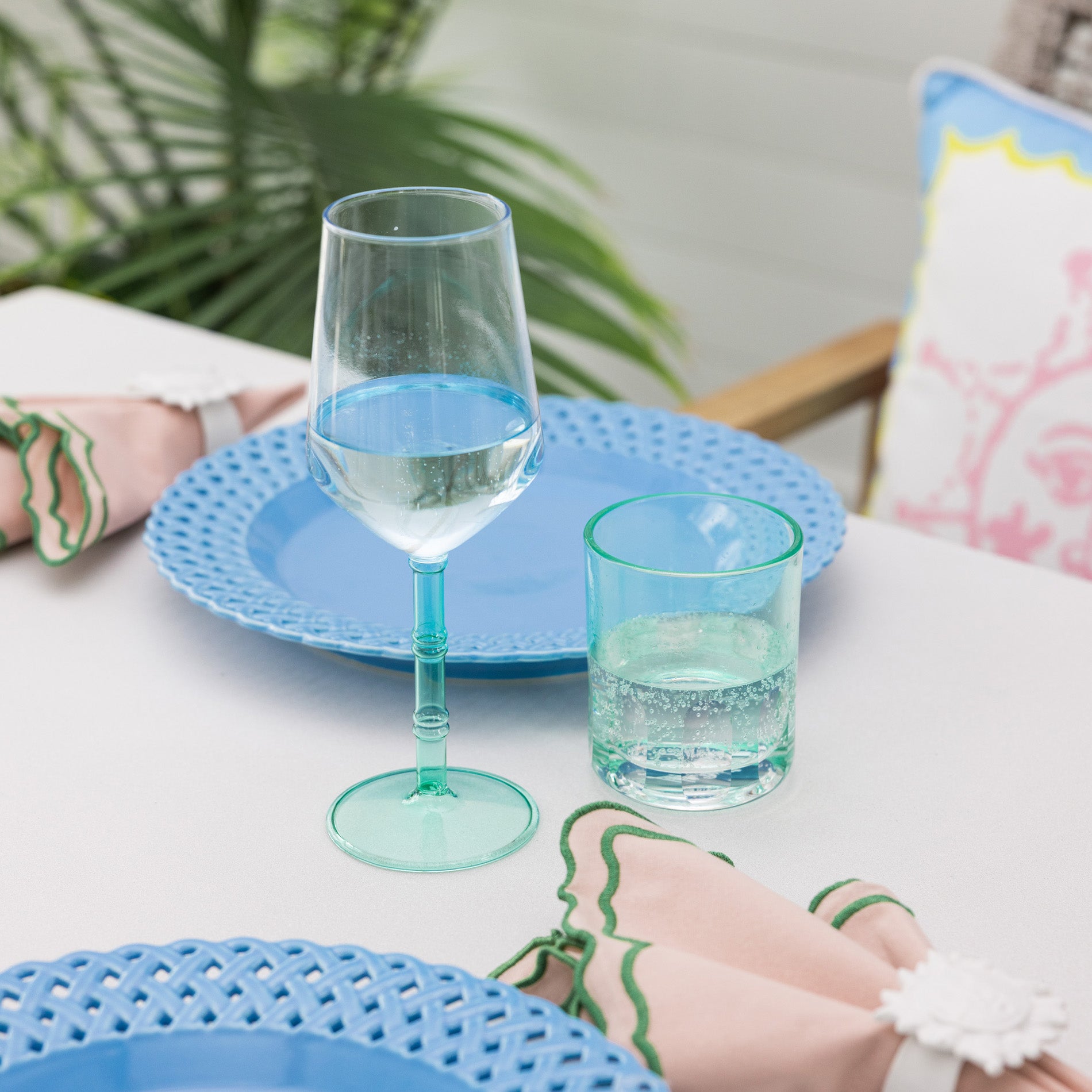 Two turquoise glasses on a table with a blurred background