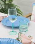 Two turquoise glasses on a table with a blurred background