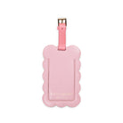 Pink luggage tag with scalloped edge and 'kate spade' branding on a white background