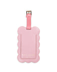 Pink luggage tag with scalloped edge and 'kate spade' branding on a white background