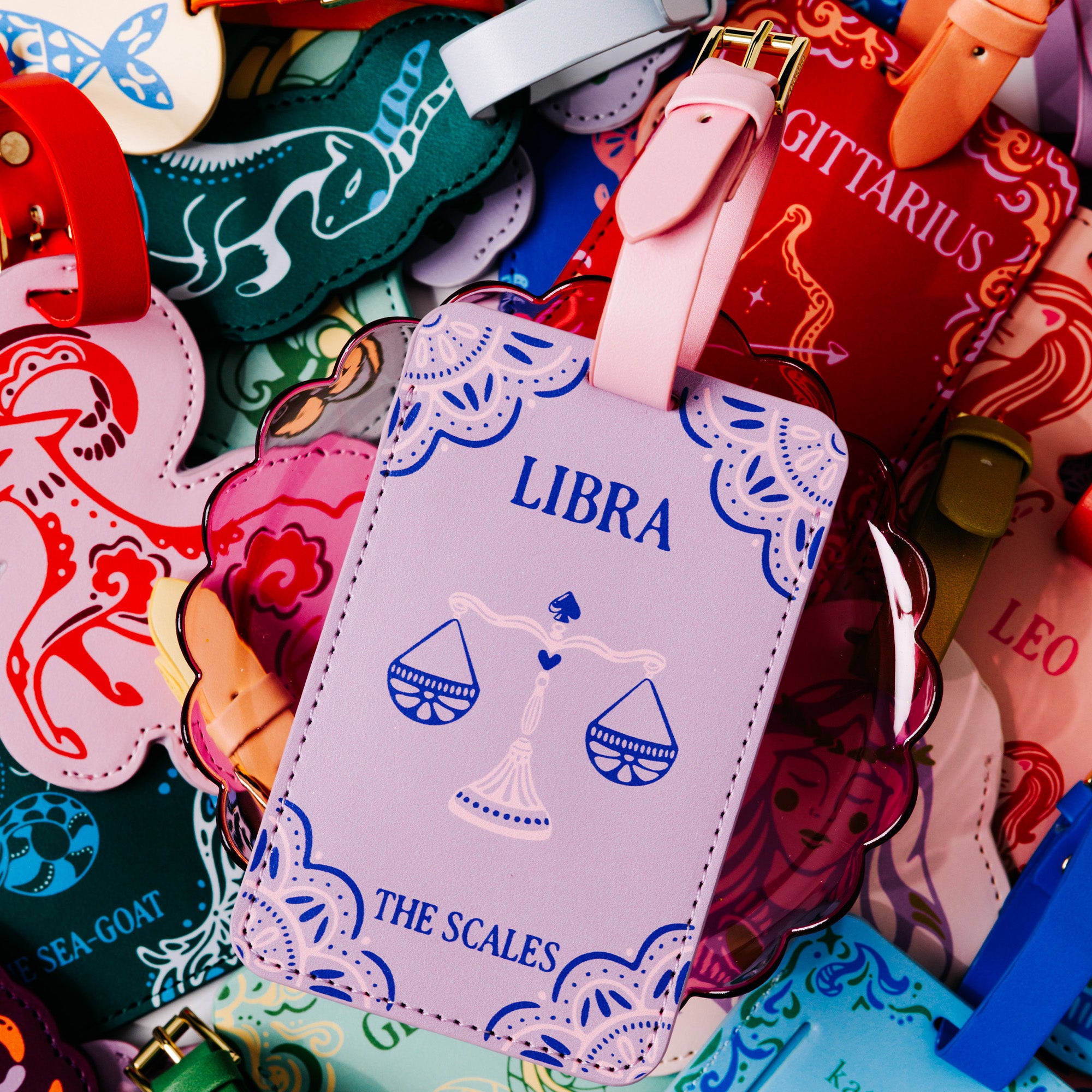 purple luggage tag with 'LIBRA' and 'THE SCALES' with scale image