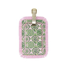A rectangular luggage tag with a pink fringed border and a green botanical pattern insert, featuring a gold-tone metal loop at the top, shown on a plain white background.