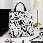 Floral patterned lunch bag on a desk with a laptop and other items.