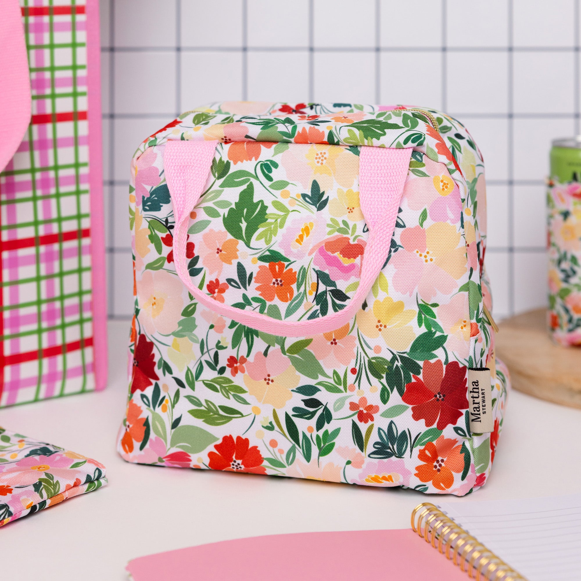 Floral-patterned bag with pink handle on a white surface