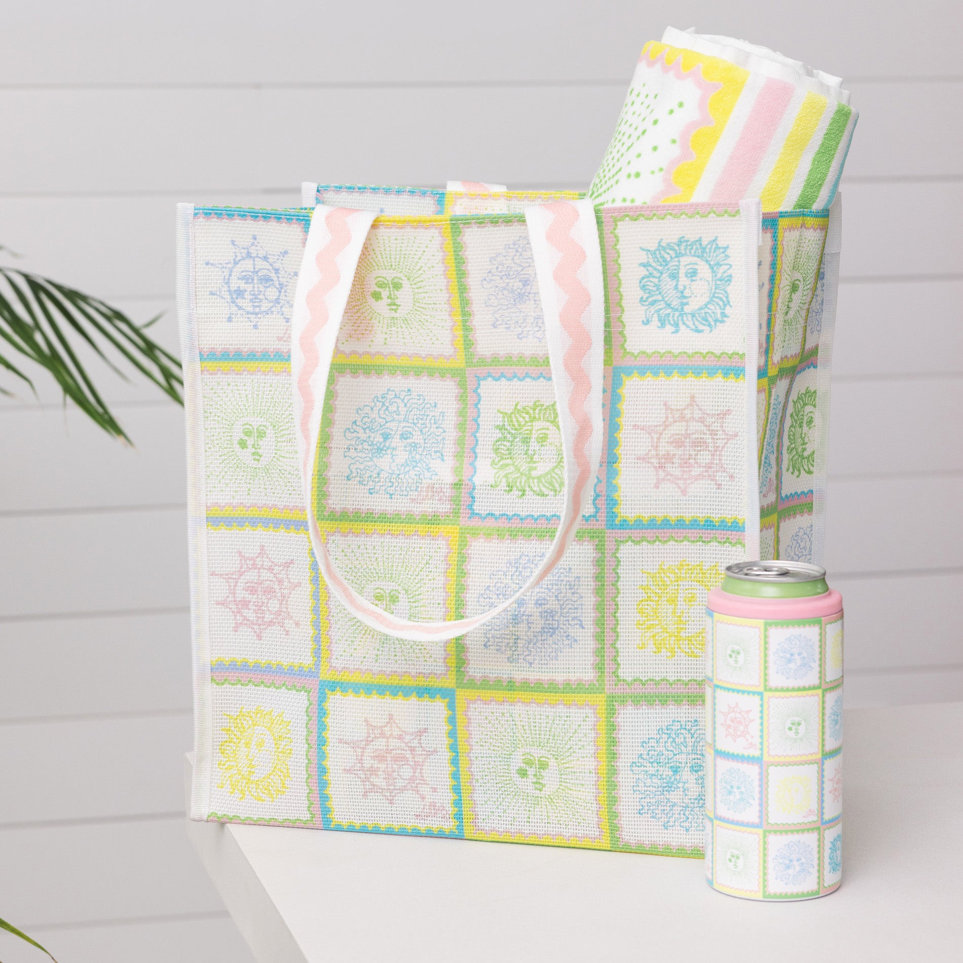Tote bag, blanket, and can cooler with pastel pattern on a light gray background