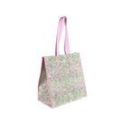 side view of light green and pink patterned reusable shopper bag with pink handles, shown on a plain white background.