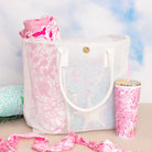 white mesh beach bag with a pink floral towel and matching tumbler