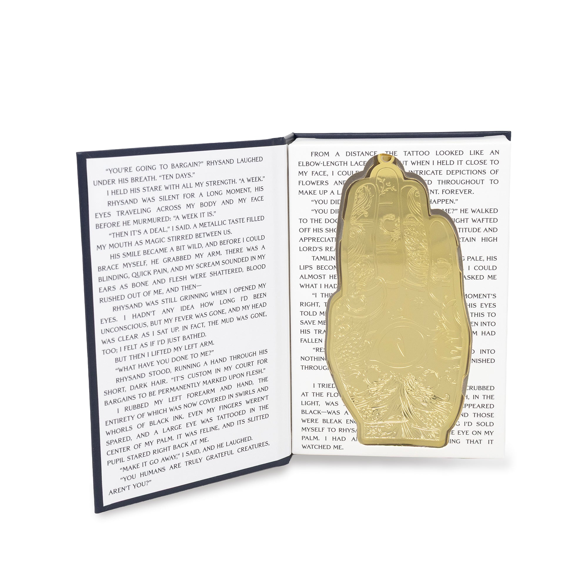 A gold-toned metal hand, displayed on an open book with printed text.