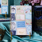 Notebook with decorative stamps on a silky teal background