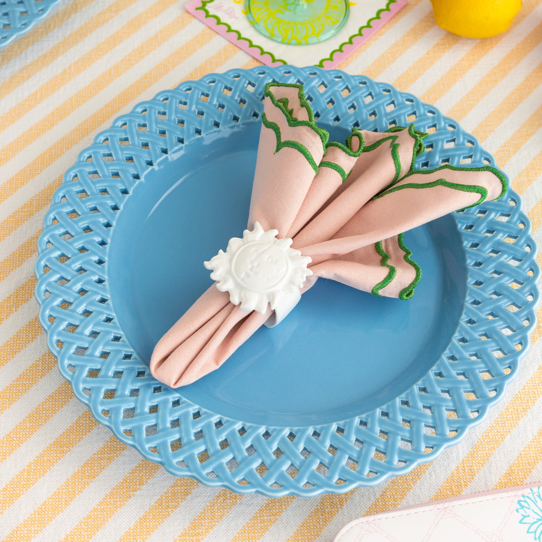 white sun napkin ring with a pink and green napkin inside