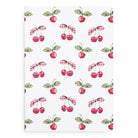 Patterned fabric with cherries and checkered leaves on a white background