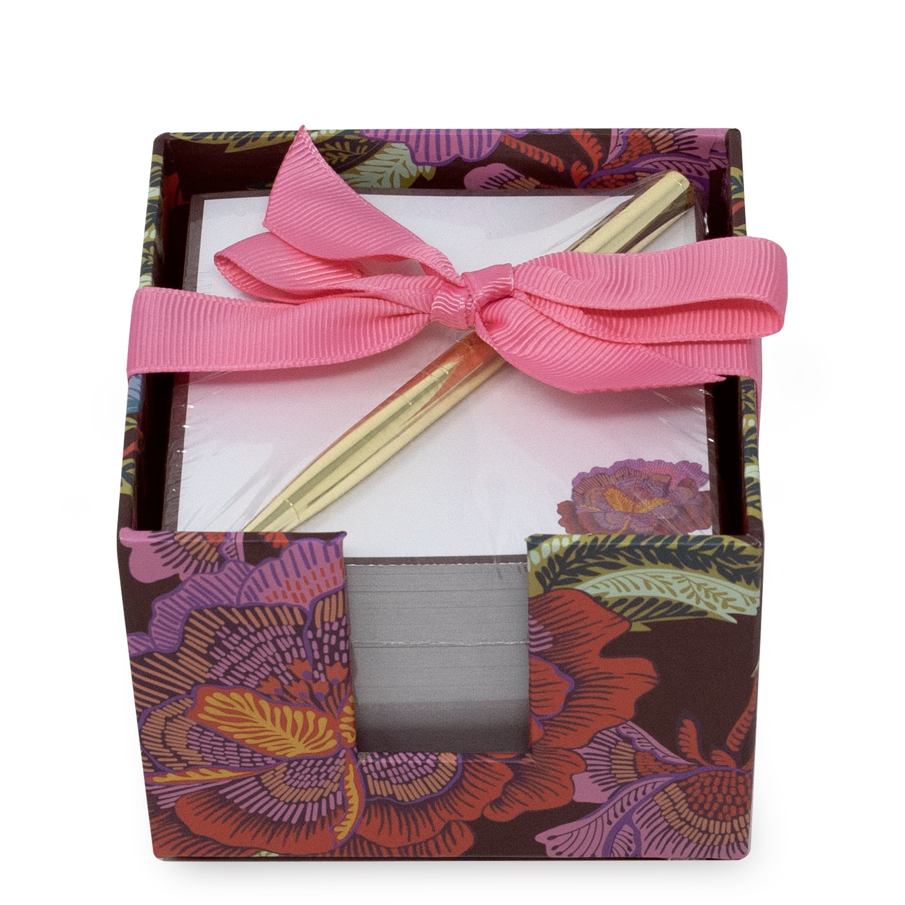 A square notecube with a colorful floral pattern, tied with a pink ribbon bow and containing a gold metal pen on white tissue paper.