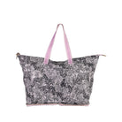 A large tote bag featuring a black and white zebra print pattern, with light pink handles and trim, shown against a plain white background.