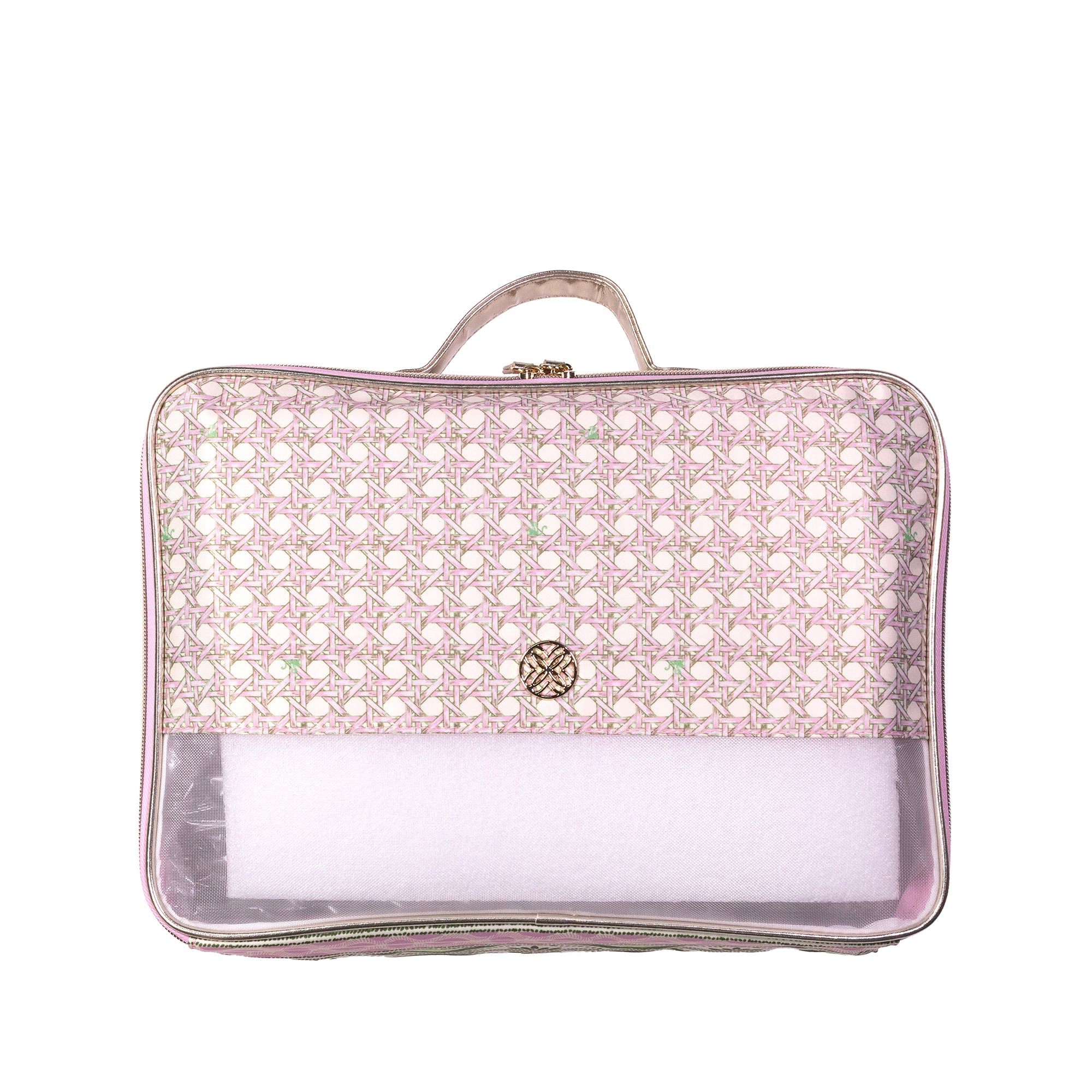 A rectangular travel packing cube with a top handle, featuring a light pink and white geometric patterned upper half, a small gold-tone circular logo on the front, and a clear plastic bottom compartment containing white packing paper.