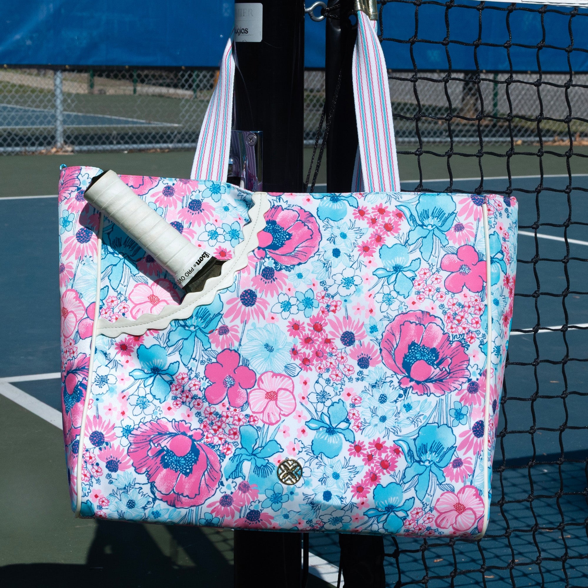 Floral tote bag with a pickleball racket on a pickleball court