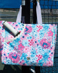 Floral tote bag with a pickleball racket on a pickleball court