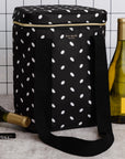 Black polka dot wine cooler bag with bottles and a corkscrew on a tiled wall background