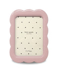 Pink photo frame with scalloped edges and 'kate spade new york' branding on a white background.
