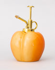 Back view of Peach-shaped bottle with gold nozzle on a white background